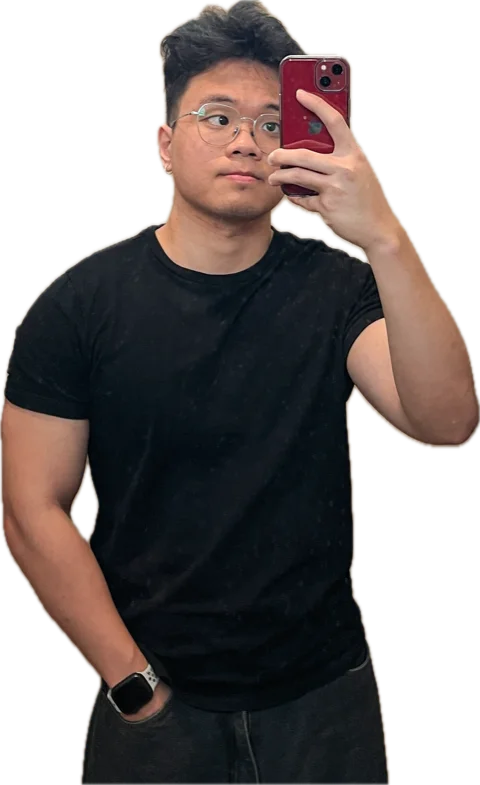 Thang Pham, in a black T-shirt and glasses, holding up a phone